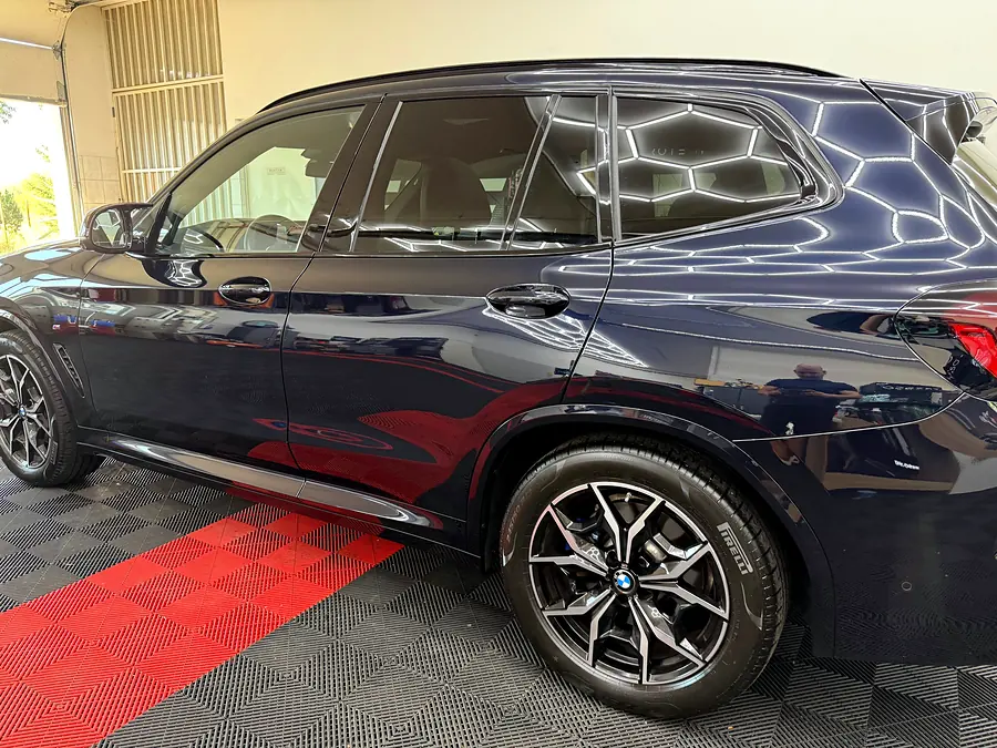 BMW X3 oldala, a fényezésen tükröződő hatszög-lámpákkal