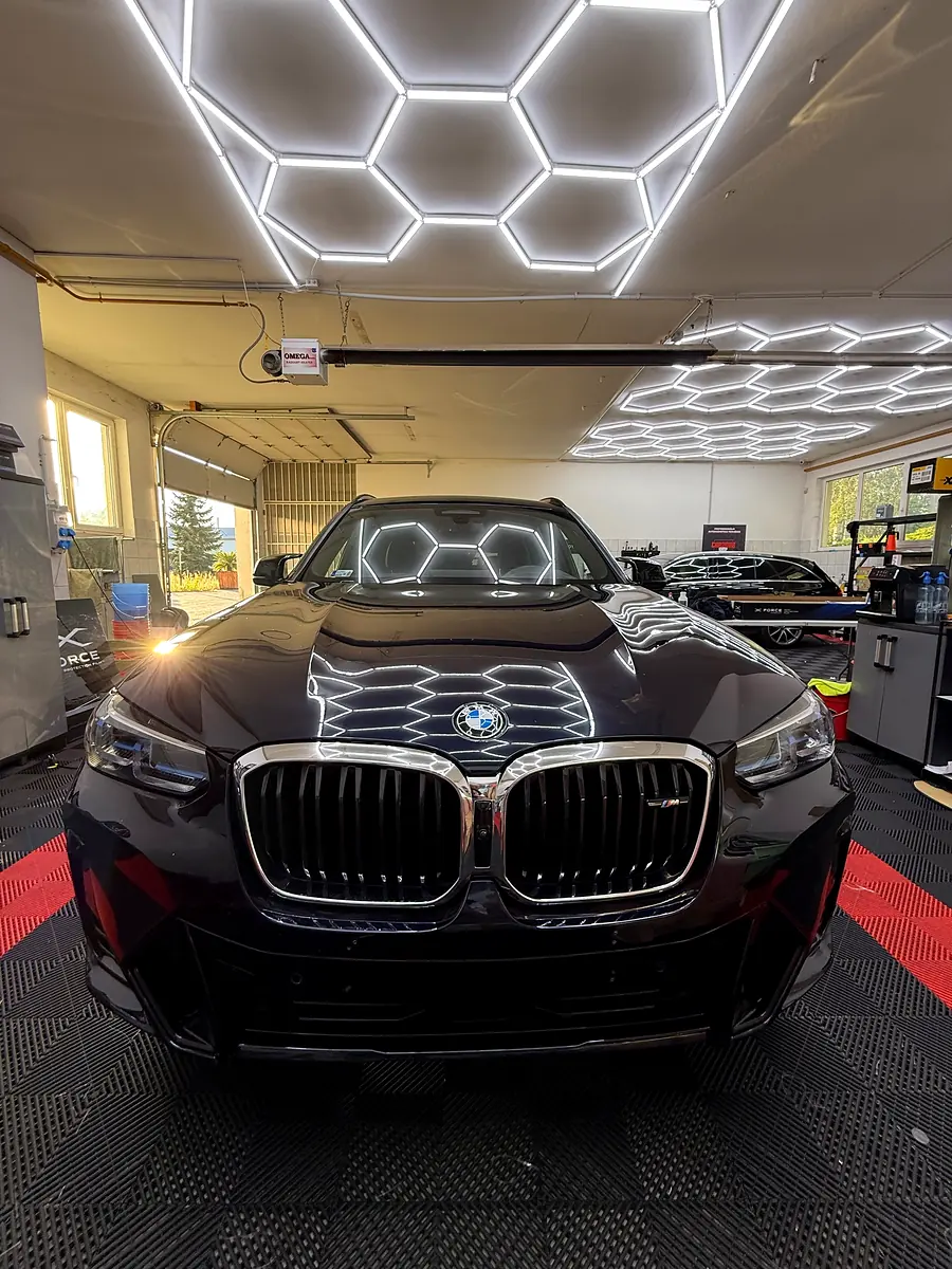 BMW X3 szemből, a hatszög-lámpák tükröződnek a motorháztetőn